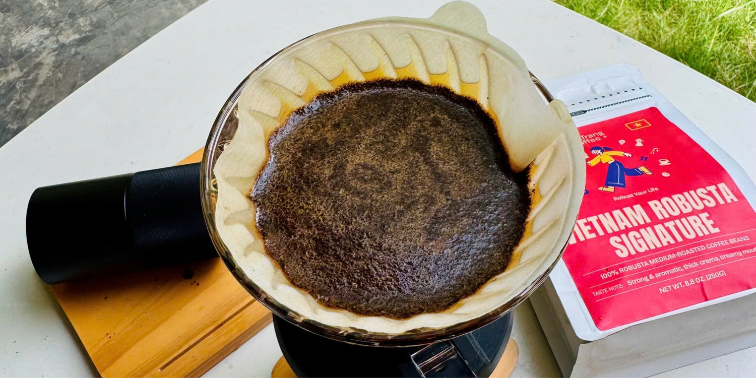 Vietnamese Robusta coffee drip brew with filter and packaged coffee beans on table